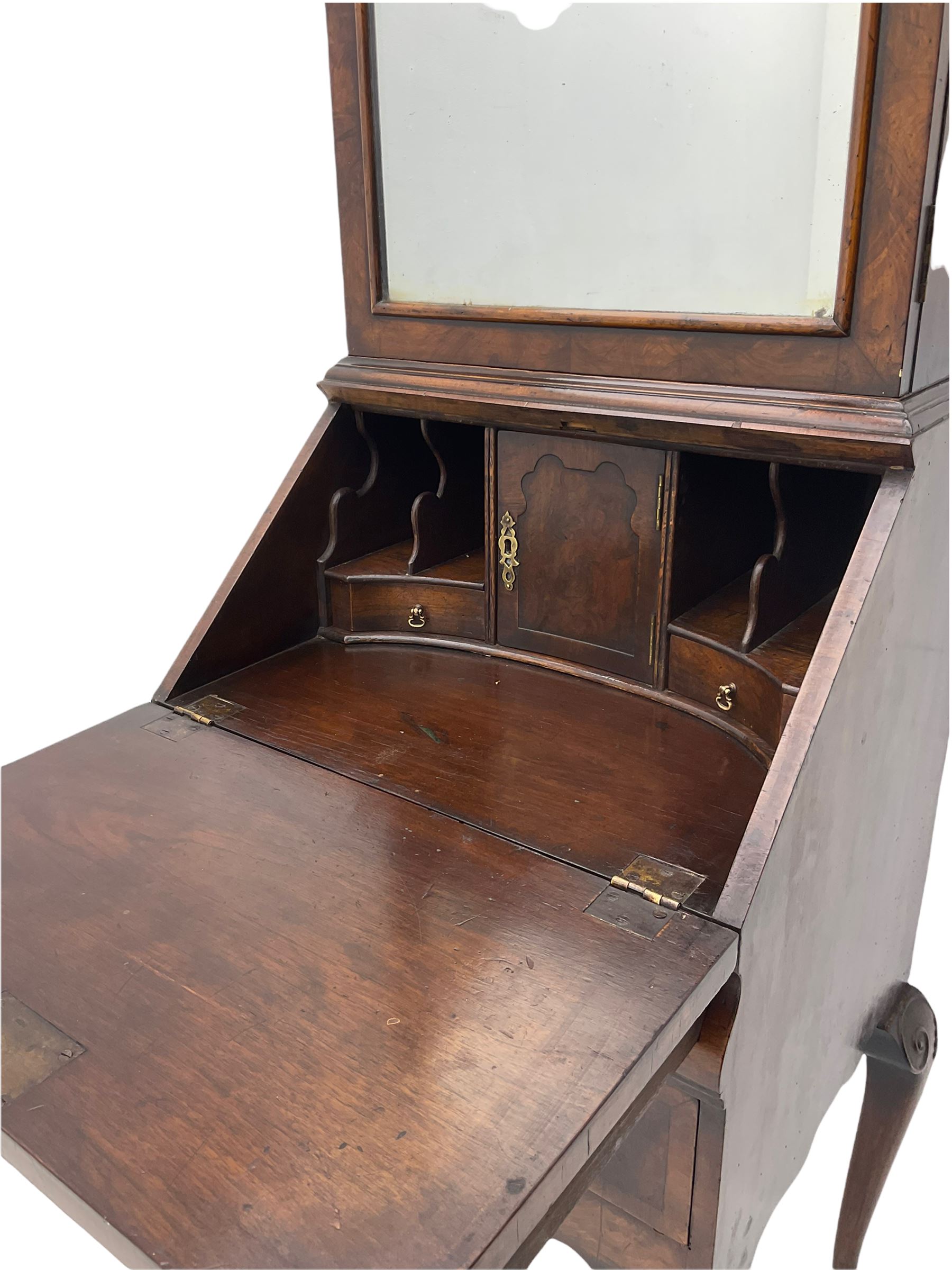 Small early 20th century Queen Anne style bookcase on bureau secretaire, the moulded arched pediment over mirrored door in shaped frame, the bureau fitted with fall front enclosing curved fitted interior, cushion moulded drawer over single drawer, on scroll and shell carved cabriole supports