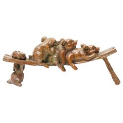 Bronze figure of three pigs resting on a bench, W10cm 