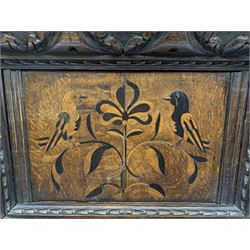 Late 17th/early 18th century oak, ebony and fruitwood marquetry panel depicting two birds perched upon a central stylised flower, within a later foliate carved oak frame, H39.5cm W54cm