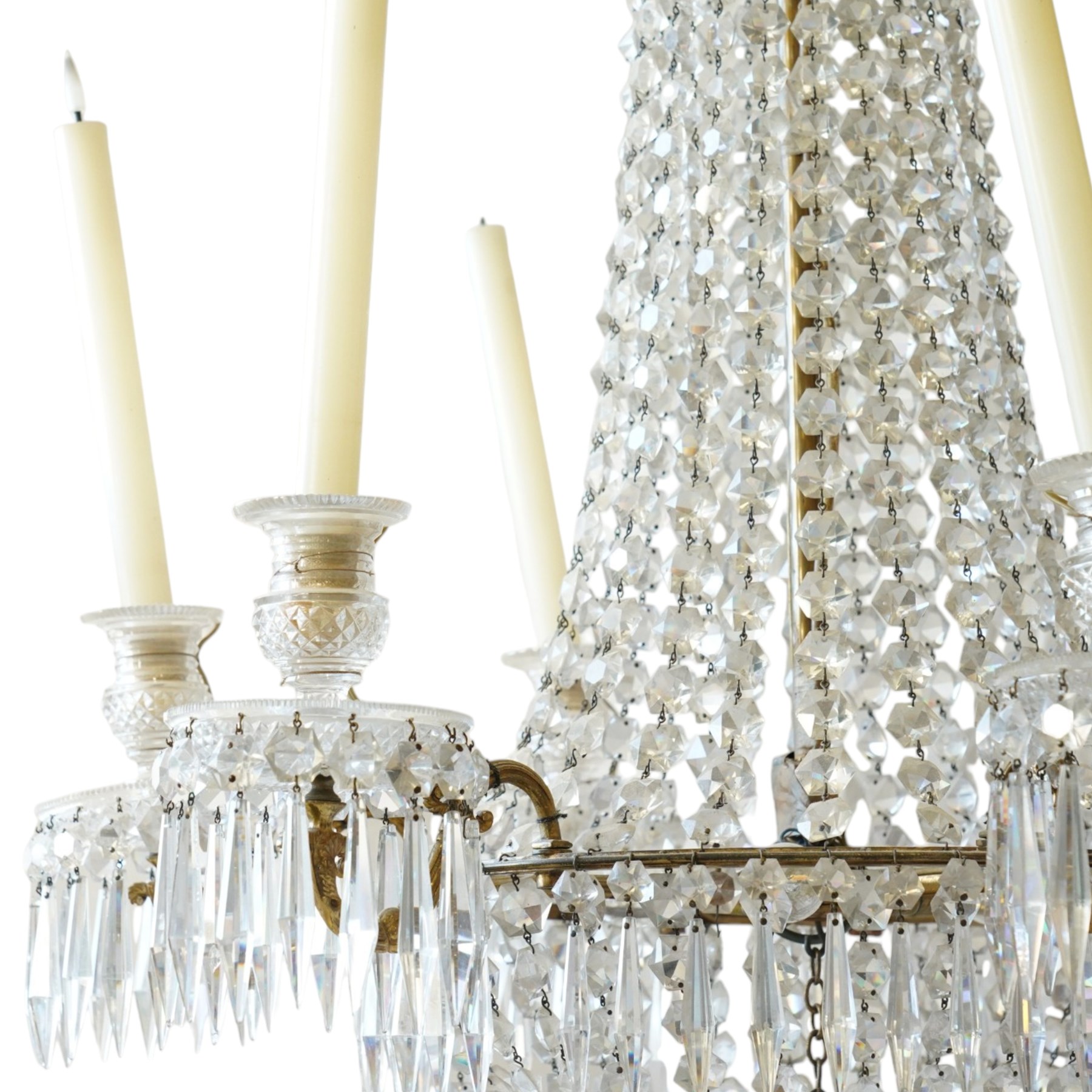 Regency Country House cut-glass and ormolu six light chandelier, the outer shaft with ormolu foliate moulding hung with octagonal and drop pendants, the impressive central shaft with cascading drops of cut-glass, the scroll branches with hob-nail cut candle holders and wax pans, with central similarly cut terminal
Provenance: property of a nobleman