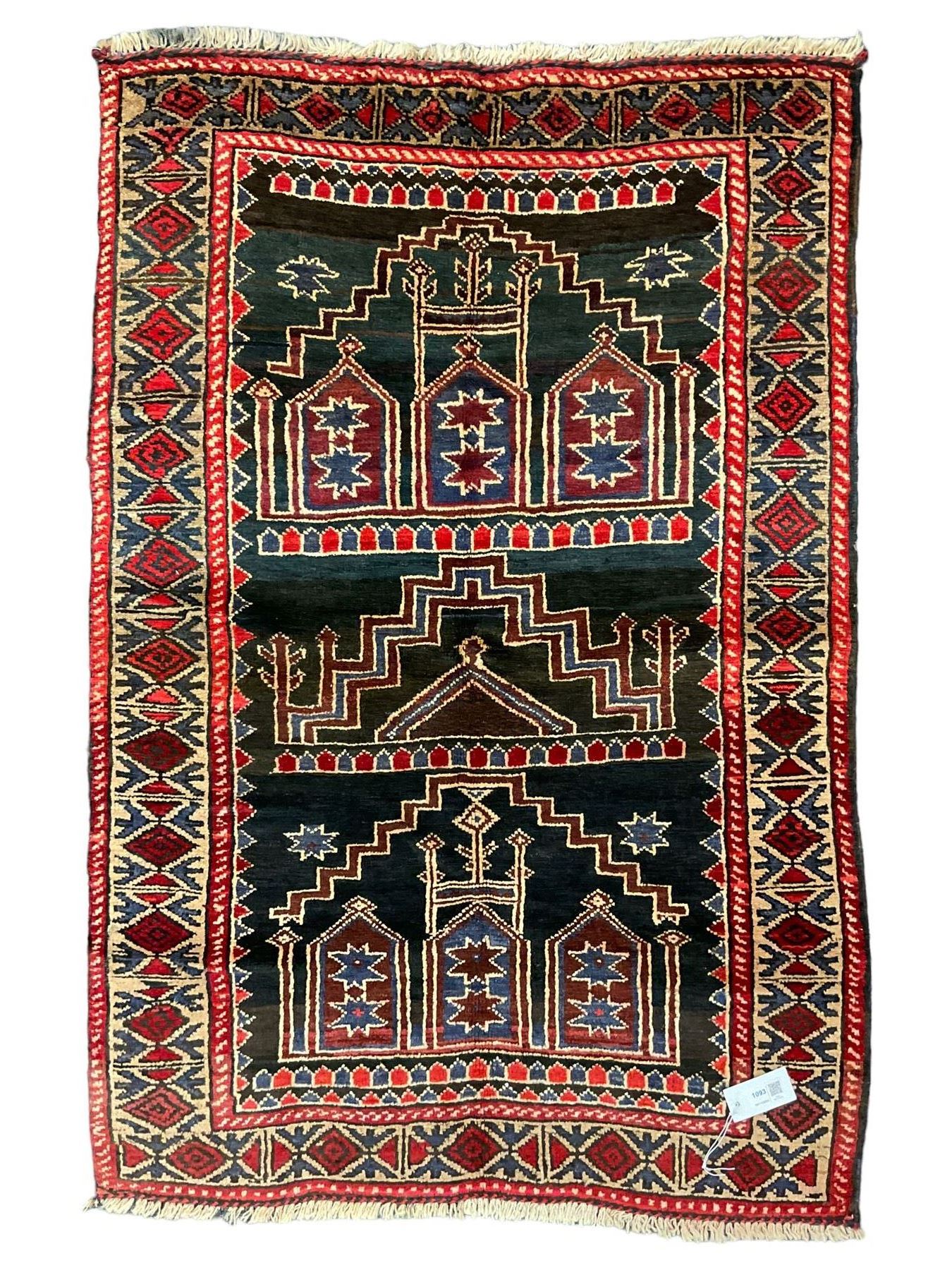 Baluchi dark indigo and crimson ground rug, decorated with cityscape within geometric border 