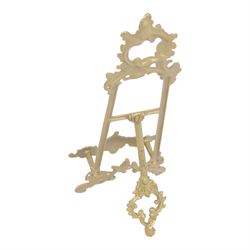 Three Baroque design brass table easels, the largest with cast mask detail, H47cm, and two matched graduated examples, smallest H25cm