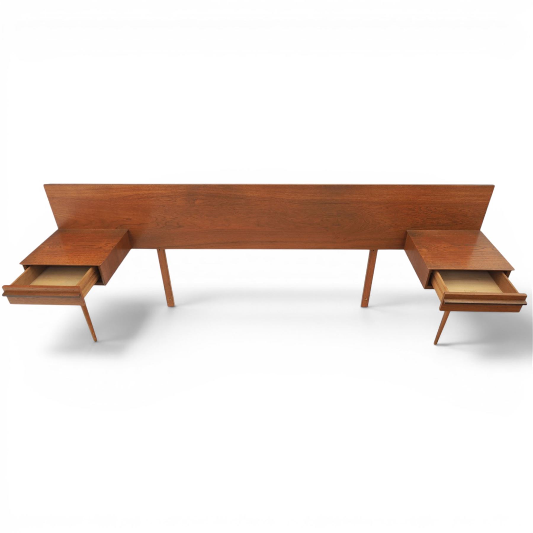 Austinsuite - mid 20th century teak headboard with bedside cabinets and matching  mirrored dressing table, the headboard with floating single drawer bedsides raised on a single tapering support, the dressing table with attached tilting mirror, above rectangular top with kneehole and two banks of two drawers, raised on tapering supports

Headboard H 84cm, D 40cm, W 229cm, W between bedsides 151cm 
Dressing table H 113cm D 44cm, W 149cm, H to underside of dresser 61cm
