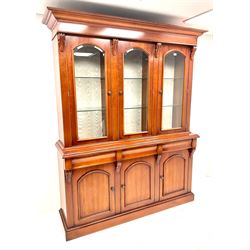 Waring & Gillow three door bookcase on cupboard, illuminated interior with hinge touch control, three bevel edged glazed cupboard doors enclosing nine adjustable shelves, three drawers above three cupboards, platform base