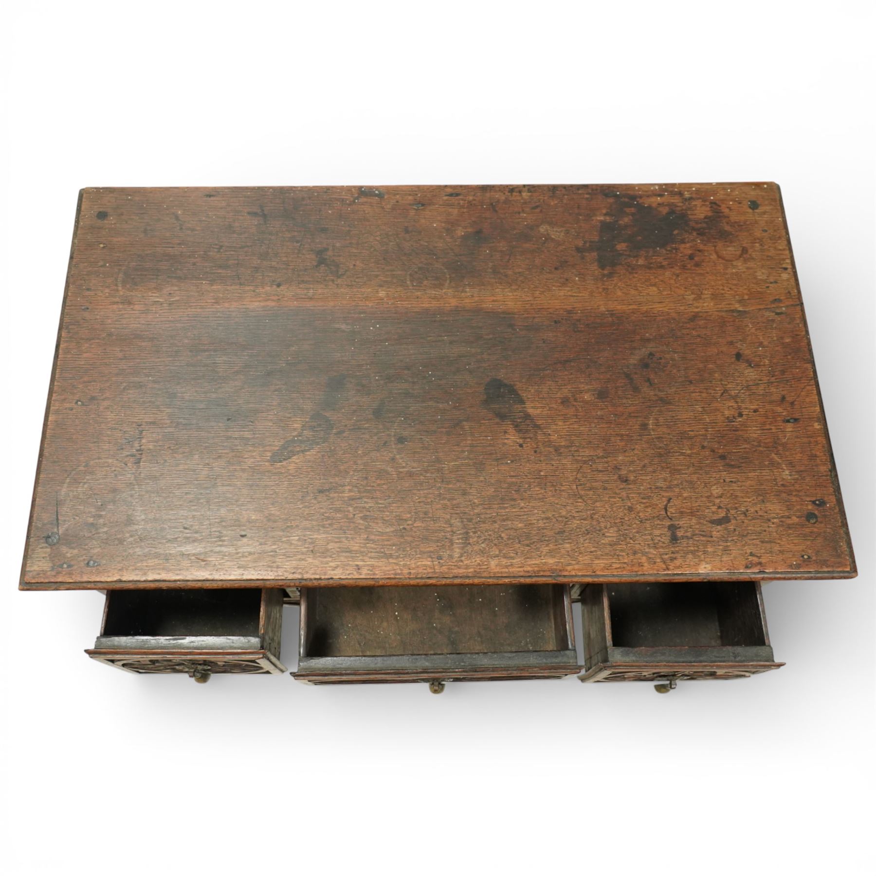 Early 20th century carved oak lowboy, rectangular moulded top above three short drawers carved with flowerhead panels and fitted with brass drop handles, shaped apron with foliate carving, raised on cabriole supports terminating in pad feet