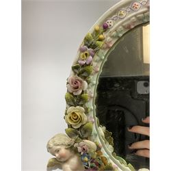 A late 19th century Sitzendorf mirror, the floral encrusted frame with two applied cherubs, with easel style support verso, and mark to upper edge, when laid flat H30cm. 