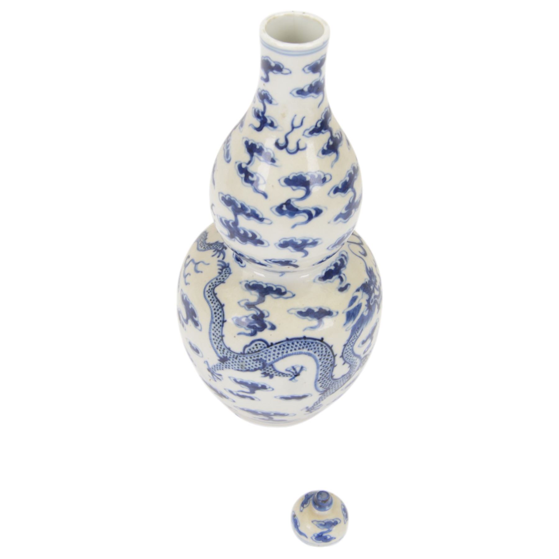Chinese Kangxi style double-gourd form vase, the blue and white vase surmounted by a domed cover, decorated with dragons chasing a flaming pearl, four-character mark to beneath, H31cm