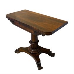 William IV rosewood card table, rounded rectangular swivel and fold-over top with plain frieze, with carved scrolled brackets above stop-fluted column with moulded collar on quadriform base with scrolled feet 
