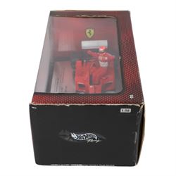Signed Michael Schumacher Hot Wheels Ferrari 1:18 scale model, 2002 five-times World Champion edition depicting Schumacher sitting on the side of his car with arms raised, with his signature in black marker to wing of car, boxed