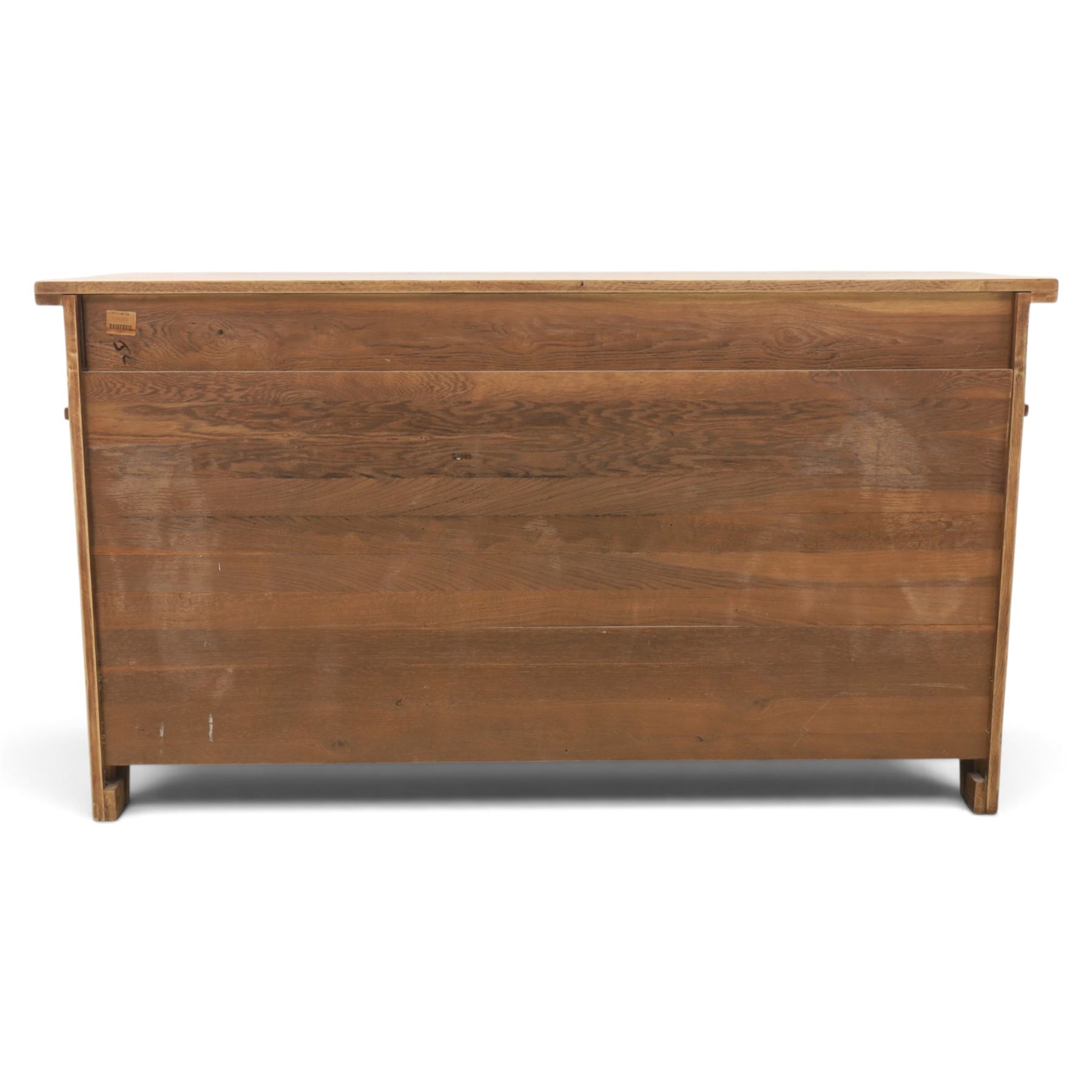 Indigo Furniture - large rustic oak sideboard fitted, with three drawers above three central drawers, flanked by fielded panelled doors, raised on bracket feet