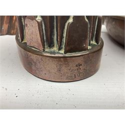 Four Victorian copper moulds, together with a graduating set of copper pans with wooden handles and finials to covers, largest pan 