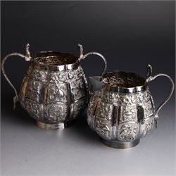Three piece Indian silver tea service, comprising teapot, twin handled open sucrier and cream jug, each with embossed animal decoration with fish border, serpent handles and elephant finial, teapot H17cm