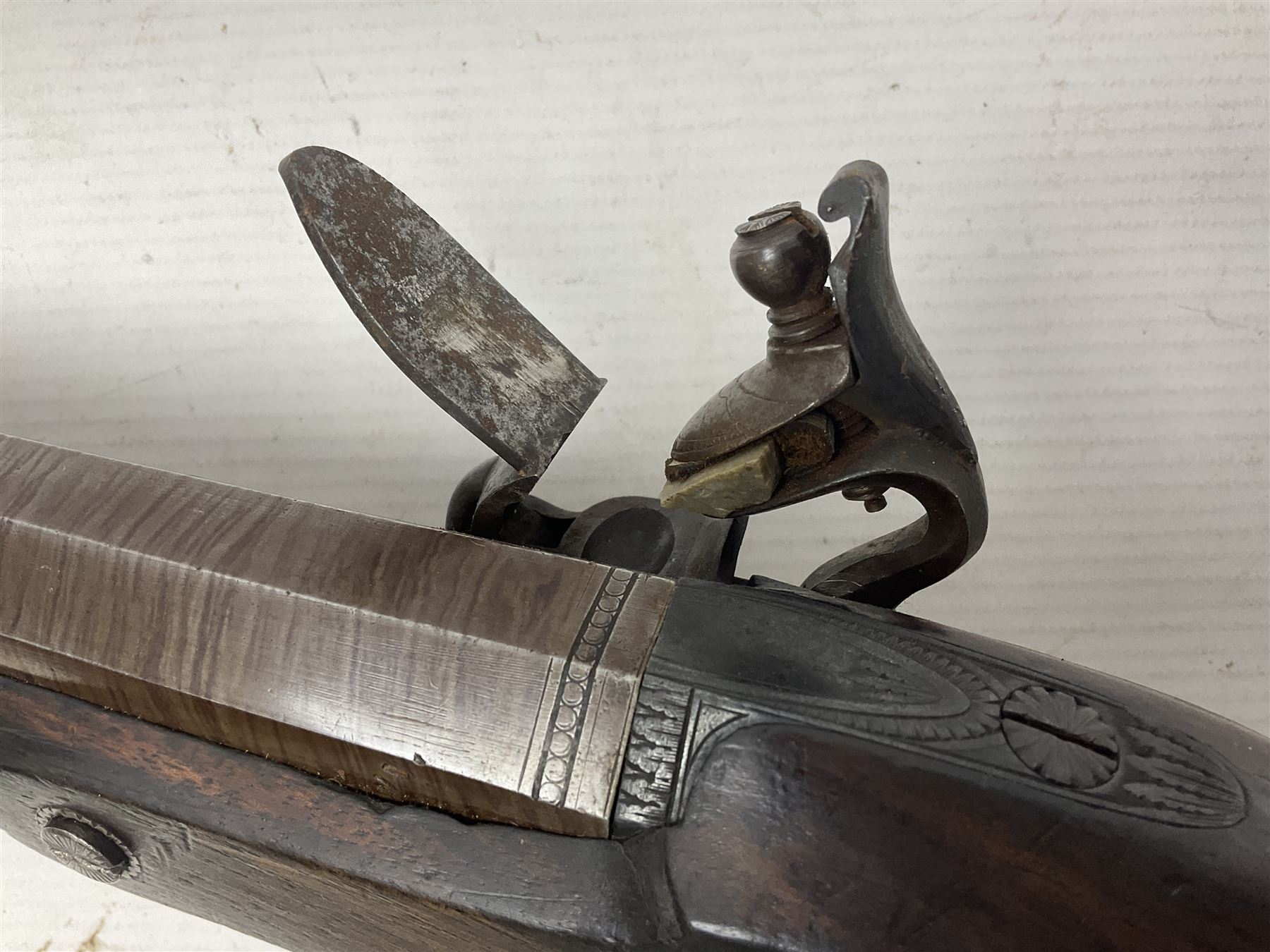 Early 19th century 16-bore flintlock single barrel travelling pistol, the 21.5cm stub twist octagonal barrel with two barrel pins and ramrod under, engraved lock plate with roller frizzen, engraved trigger guard with pineapple finial, walnut stoock with chequered grip L40cm overall