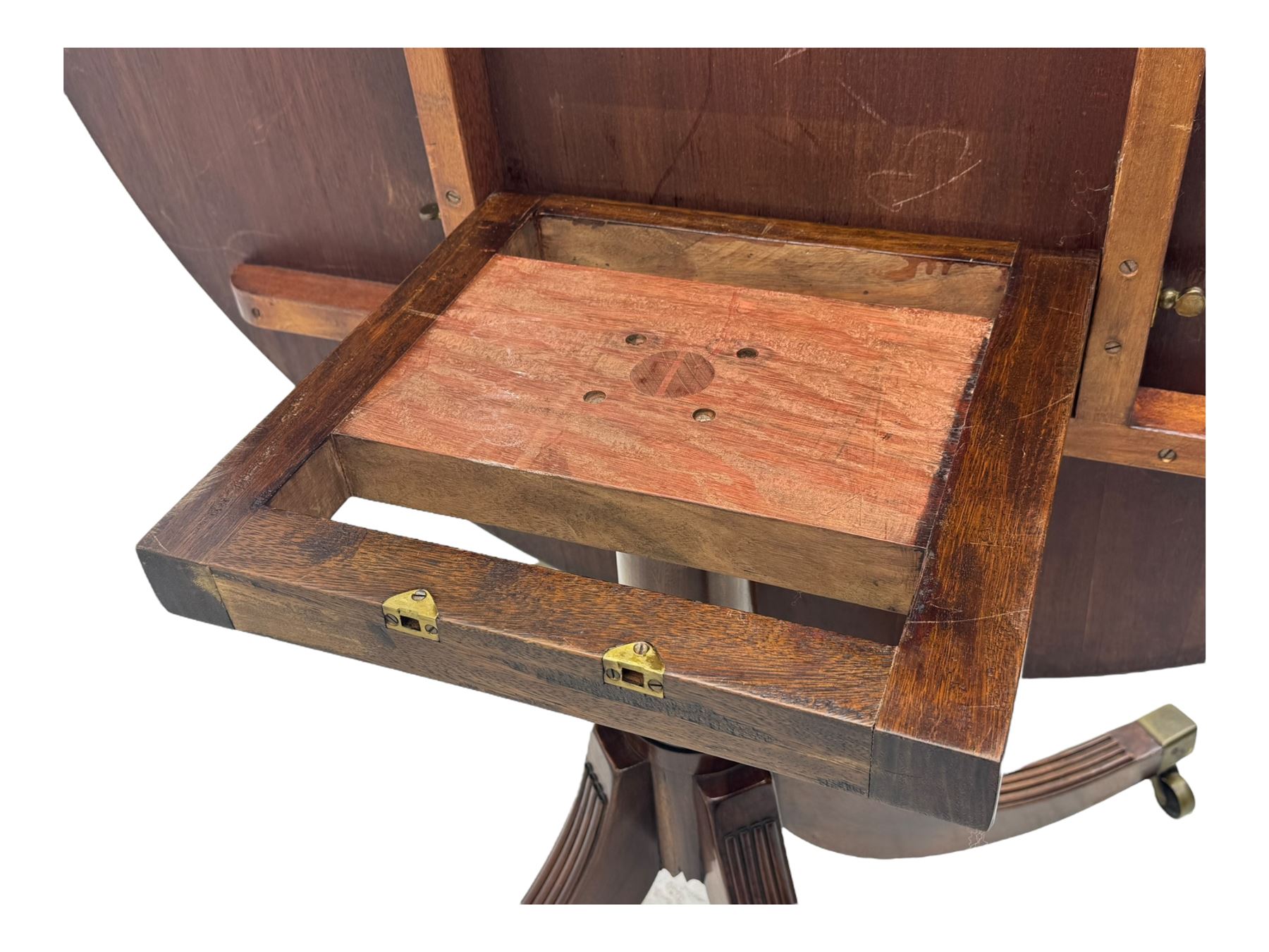 Early 20th century Regency design mahogany tilt-top table, circular top with edge banding, supported by a central turned pedestal with four reeded sabre supports terminating in castors; six chairs with pink upholstered drop in seats (7)