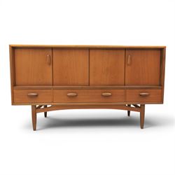 G-Plan - 'Brasilia' teak sideboard, with rectangular top above two concertina doors, above four drawers raised on cylindrical supports