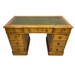 Polished pine twin pedestal desk, fitted with nine drawers, inset green leather top