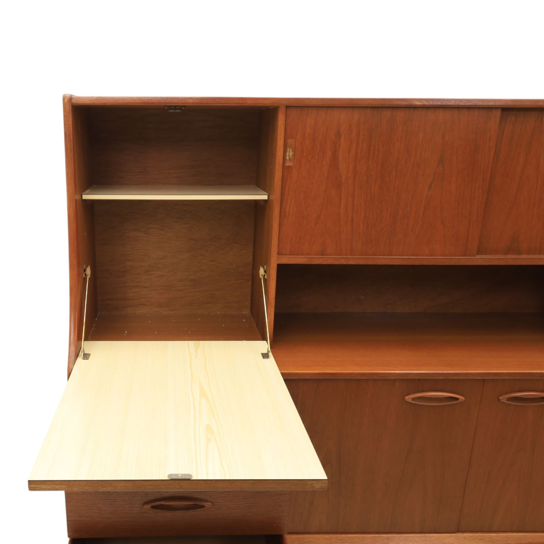 Jentique - mid-20th century teak highboard, fall front cabinet next to a sliding door cupboard above and open recess, the lower section with cabinet doors and three graduated drawers, raised on cylindrical legs