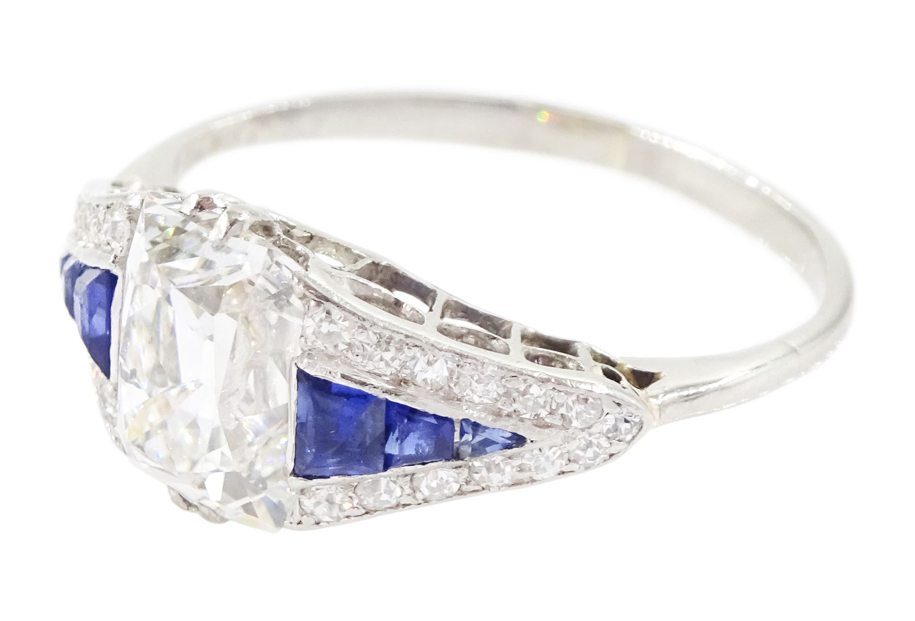 Platinum diamond and sapphire ring, the principal old cushion cut diamond of approx 1.50 carat, each side set with three graduating calibre cut sapphires and old cut diamond surround