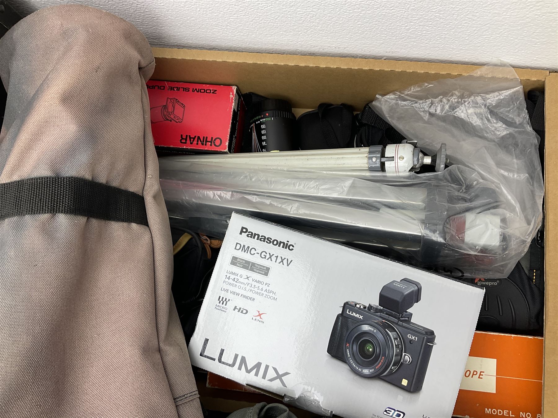 Large quantity of camera equipment in three boxes - Lumix GX1 camera, Canon EOS 500 camera, Lumix FZ100 camera, Pantax  MZ5n, various other cameras, Swift spotting Scope 20 x 60 in box,  Maxtor hard drive, three tripods, Kodak carousel projector, Pradolux slide projector, a selection of camera bags and other camera equipment. 