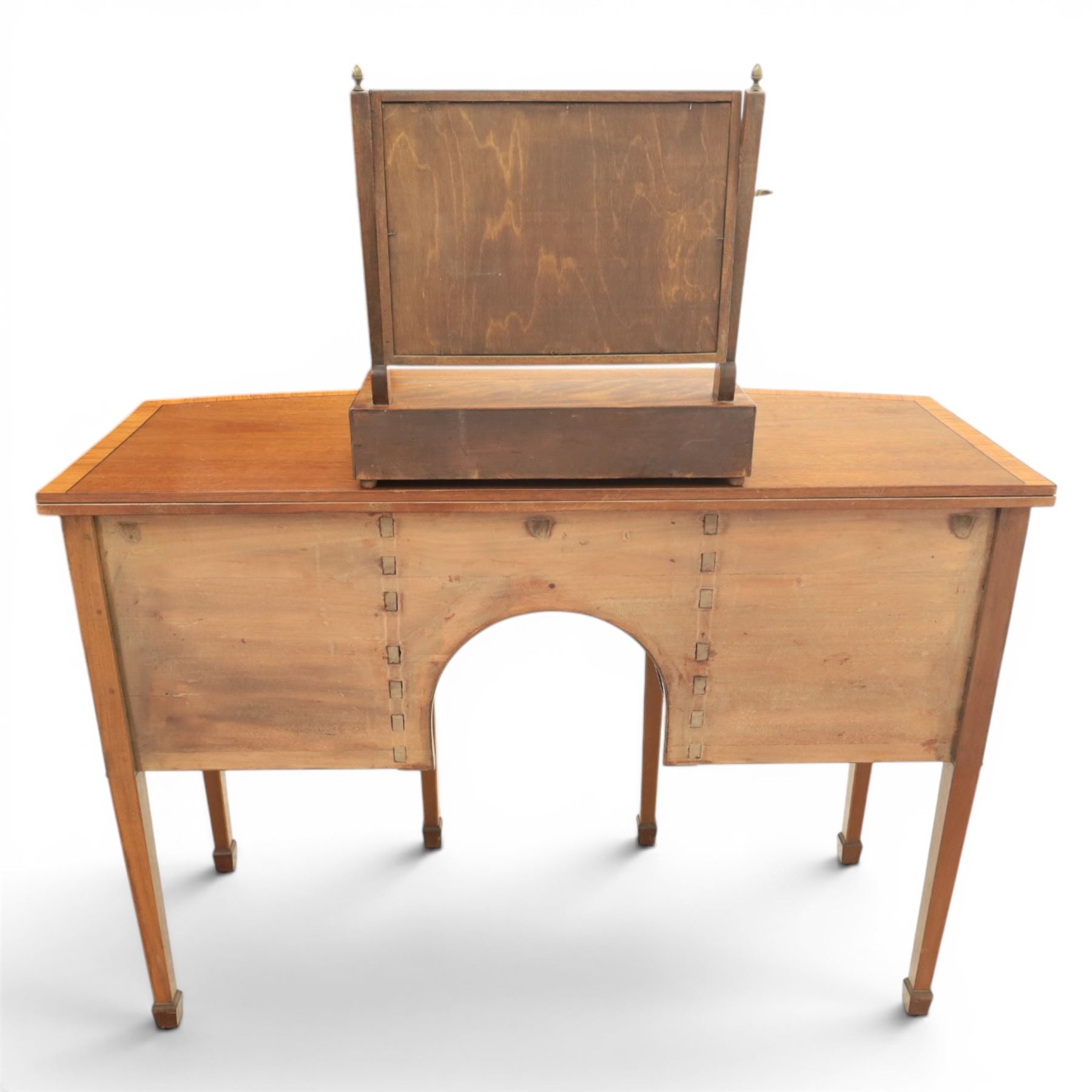 Regency design mahogany bow-front sideboard and dressing mirror, the sideboard with satinwood stringing, central frieze drawer over shaped apron flanked by cupboard doors with oval satinwood line inlaid decoration and circular pressed brass handles, on square tapering supports, the dressing mirror fitted with two drawers to the base (Mirror H 47cm, D 19cm, W 47cm)