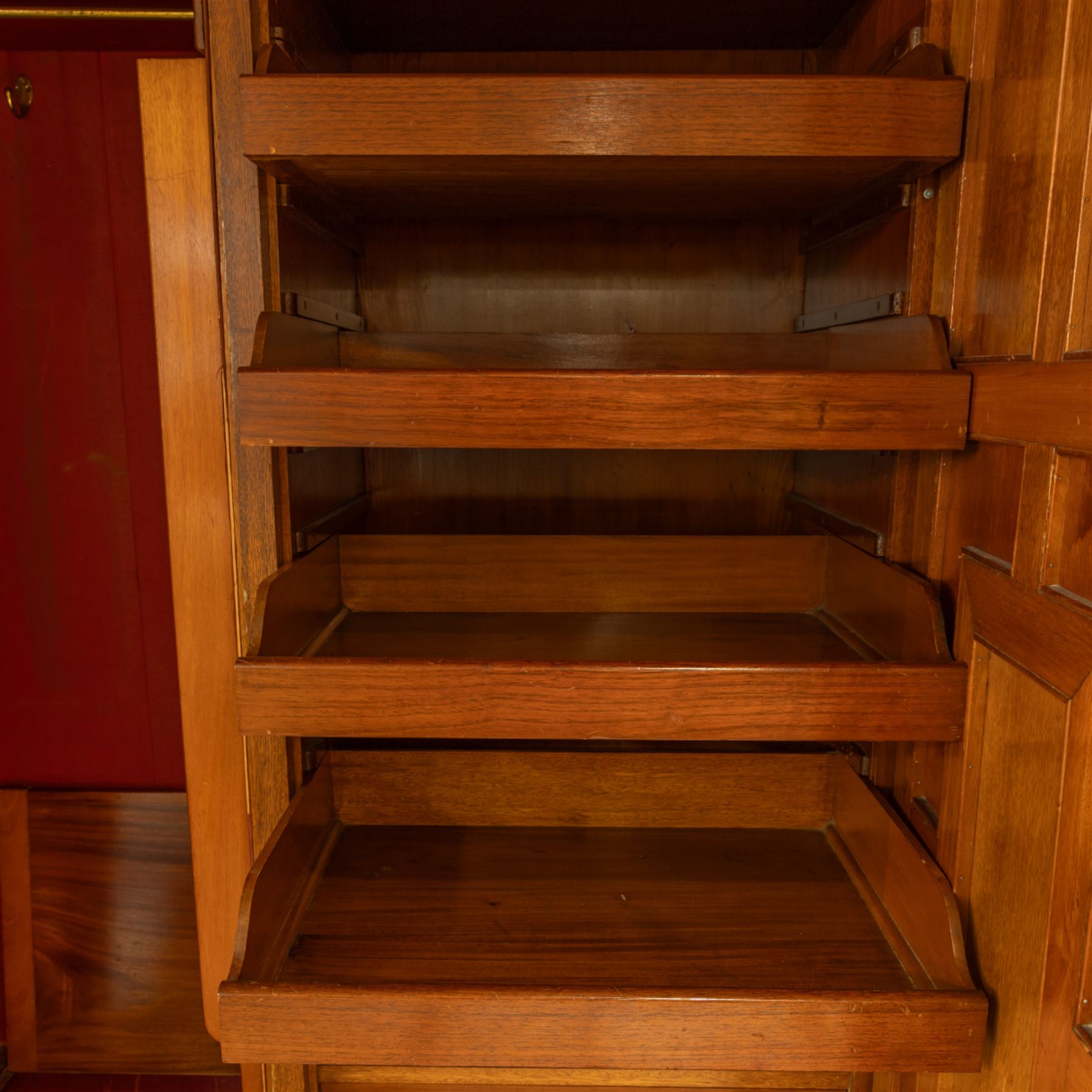 Late Victorian oak and burr oak three-section mirror wardrobe, central door with three carved panels with shell and acanthus decoration, fitted with four drawers and four tray drawers, linen sides with bevelled mirrored panel doors with hanging space, plinth base, and dental cornice
