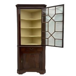 George III mahogany floor standing corner display cabinet, dentil cornice, upper astragal glazed door above small drawer and lower cupboard, on bracket feet, in two sections
