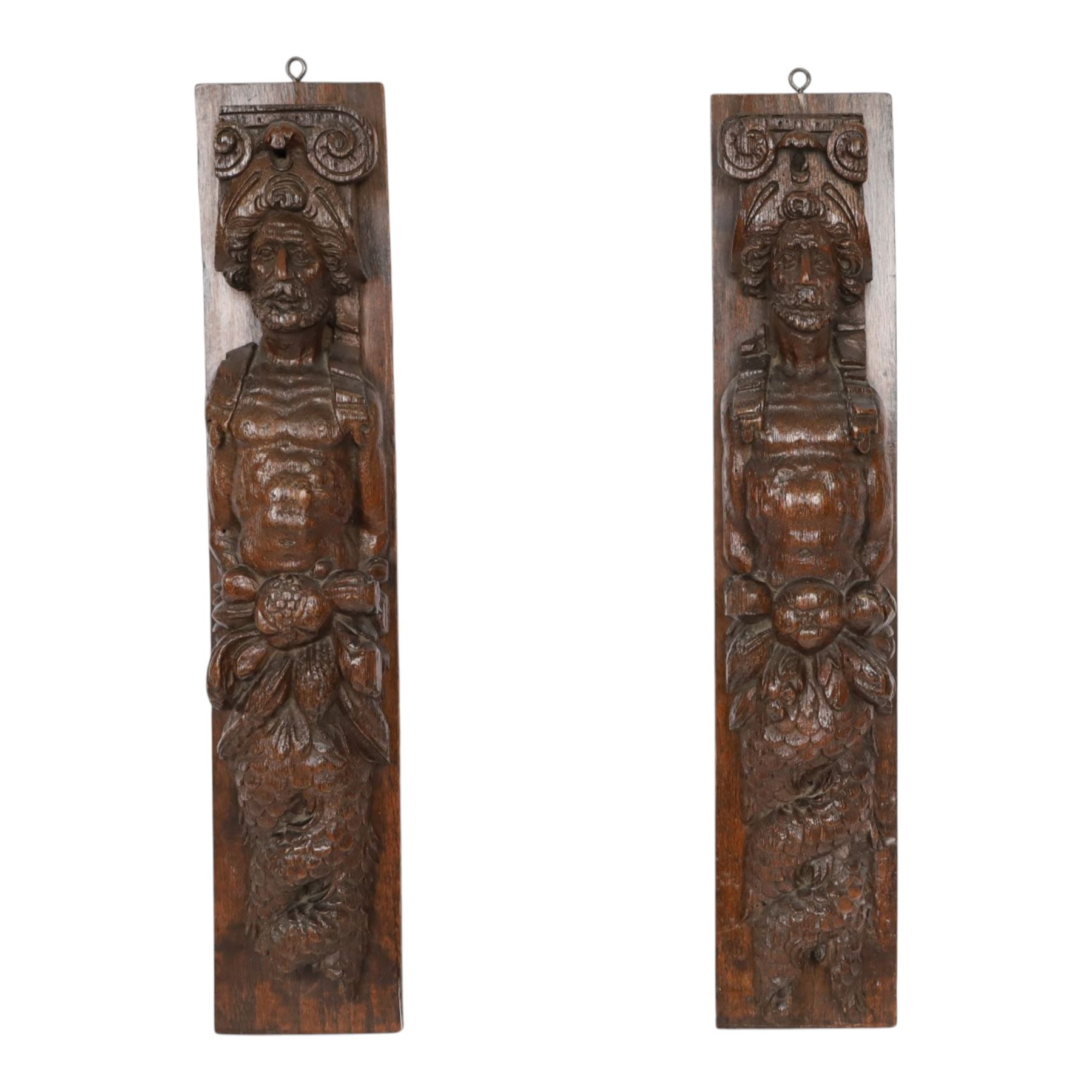 Pair of 17th century carved oak terms, each depicting a male figure in headpiece, with fish tail beneath fruits, 51.5cm