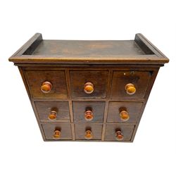 19th century oak spice rack, with moulded cornice over nine small drawers, each with turned handles, H43cm W45cm D25cm