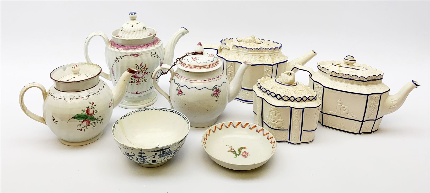 Two19th century relief moulded Castleford teapots, and lidded sucrier, largest teapot H14.5cm, together with three 18th century New Hall type teapots, an early 18th century saucer, and an 18th century blue and white bowl.