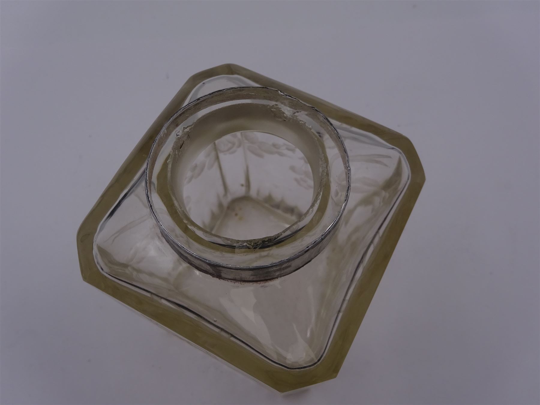 Early 20th century French silver mounted glass scent bottle, the faceted rectangular glass body etched with swags of flowers united by ribbons, with cylindrical silver cover embossed with foliate detail and beaded decoration with gilt interior, marked with Minerva's head, with white metal collar and glass stopper, H17cm