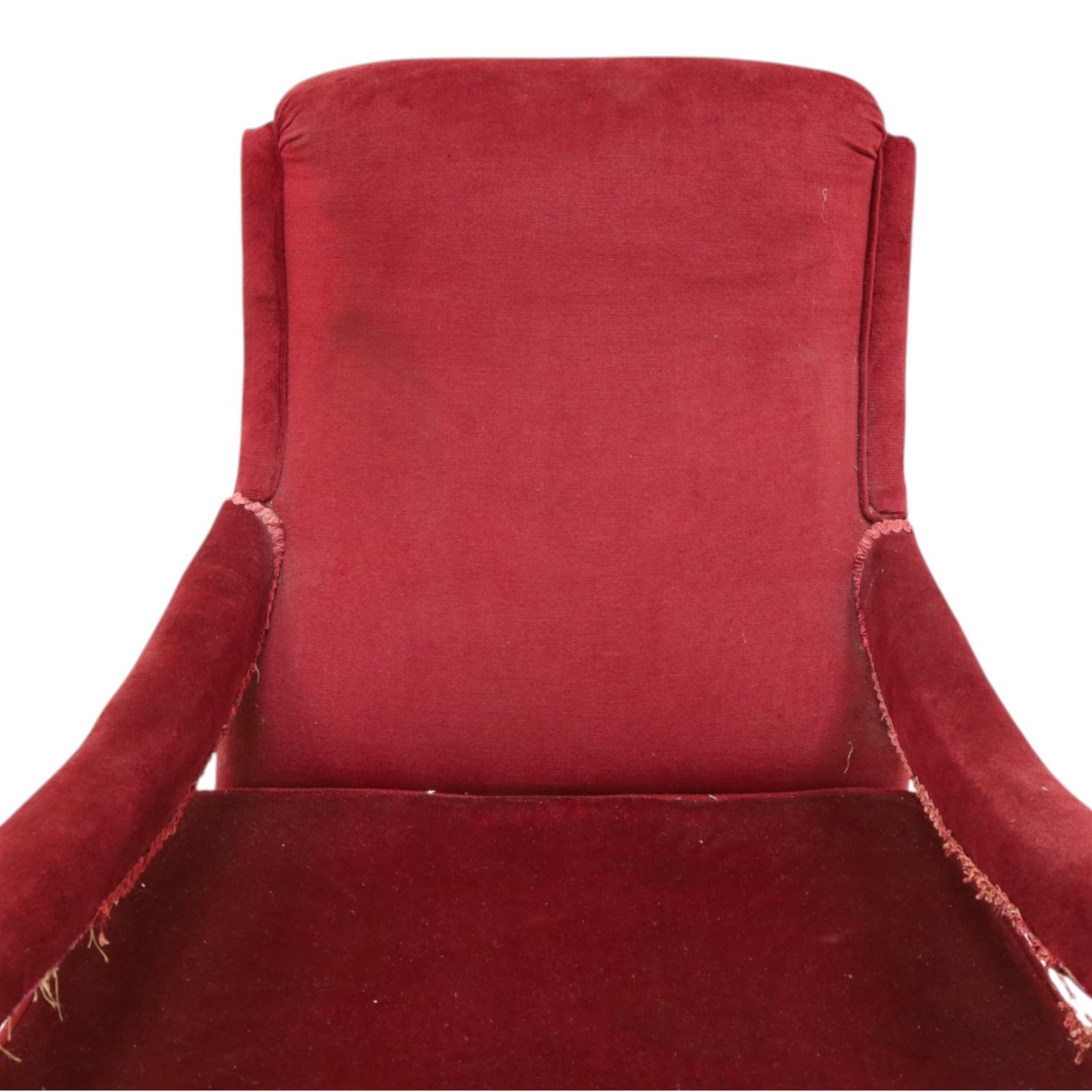 Victorian walnut framed reading open armchair of reclined position, the high sprung back and deep seat upholstered in crimson fabric with matching loose seat cushion, turned arm terminals over turned feet terminating to brass castors