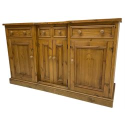 Waxed pine breakfront dresser, fitted with an assortment of four drawers and four cupboards, on skirted base