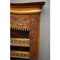  19th century walnut Delft rack, arched moulded projecting cornice, floral, acorn and bell carvings, brass studs, four shelves, W147cm, H136cm, D31cm  