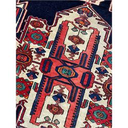 North West Persian Heriz rug, blue and ivory ground, decorated with stylised plant motifs, the border decorated with repeating geometric design 