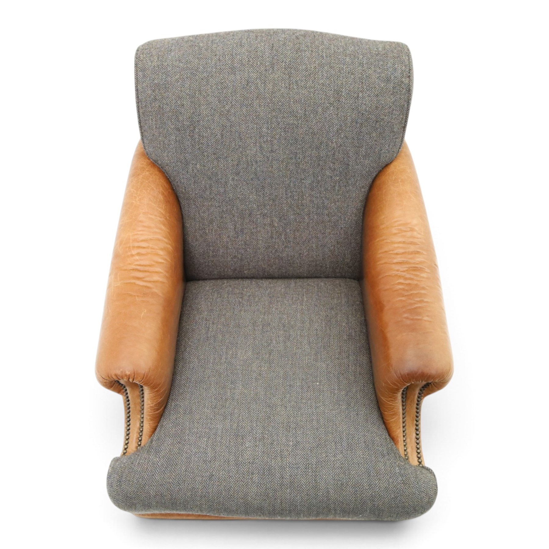Tetrad - 'Taransay' Harris Tweed and tan leather club armchair, Howard shape with reclined back over deep seat and rolled arms with studwork, raised on turned front supports with castors, the sides and arms upholstered in tan leather with seat and back in herringbone-stitched Harris Tweed