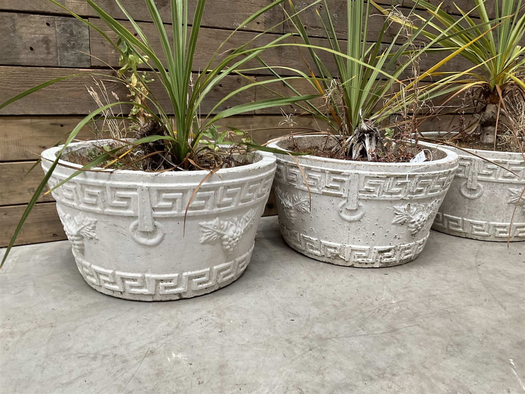 Set of four white painted cast stone circular planters
