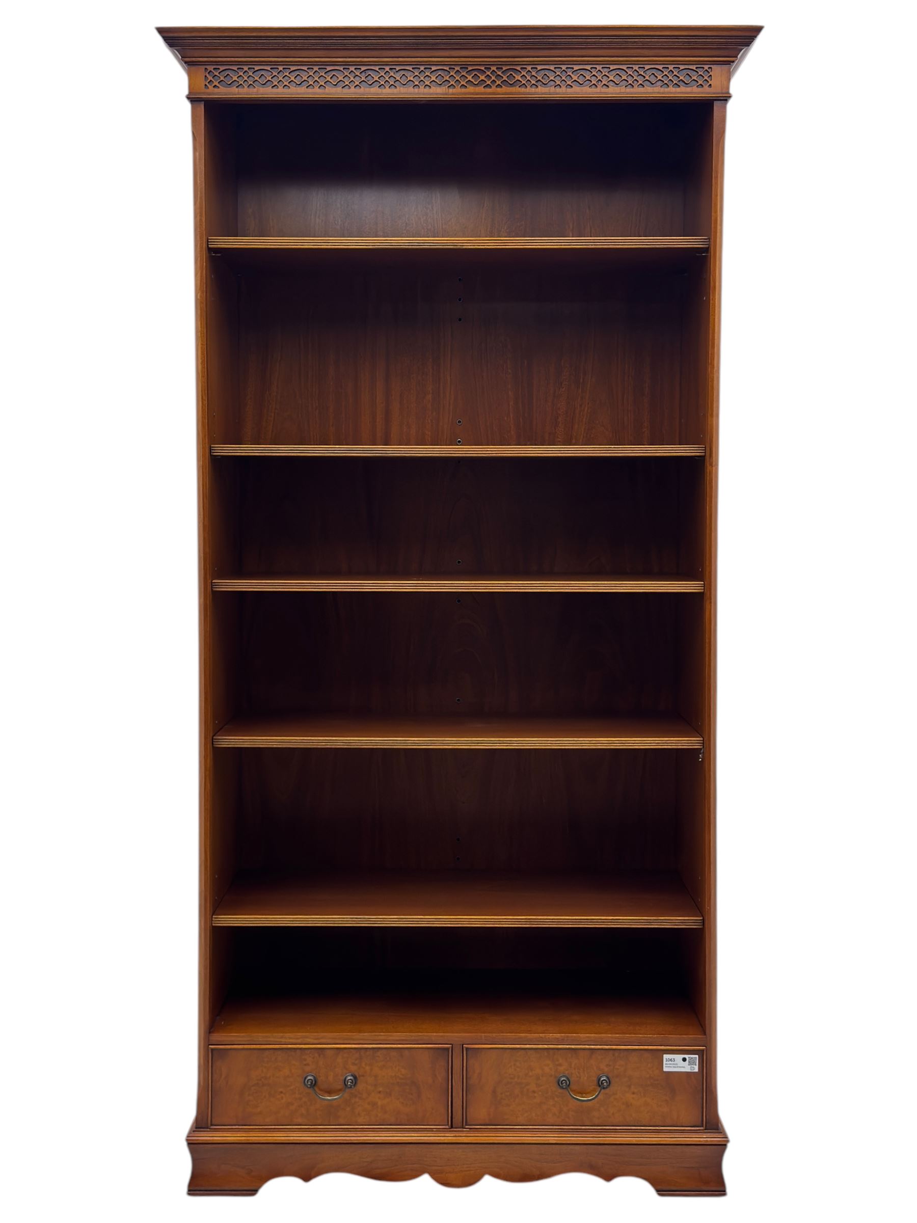 Ian Smith Furniture - Georgian design walnut open bookcase, projecting cornice over pierced geometric frieze, fitted with three adjustable fluted shelves above two drawers, on shaped plinth base 