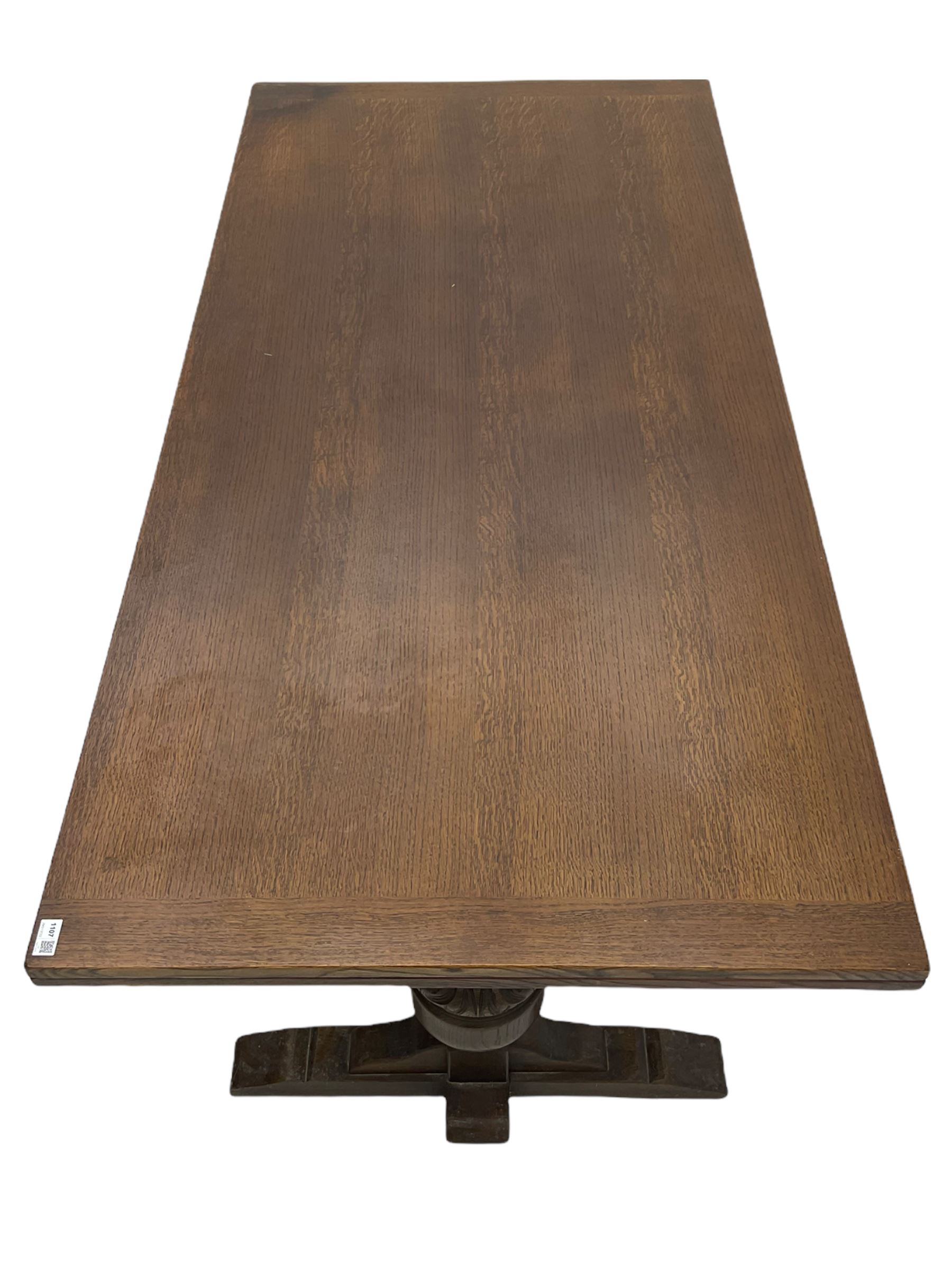 20th century oak drawer leaf extending dining table, two foliage carved baluster supports on sledge feet joined by floor stretcher 