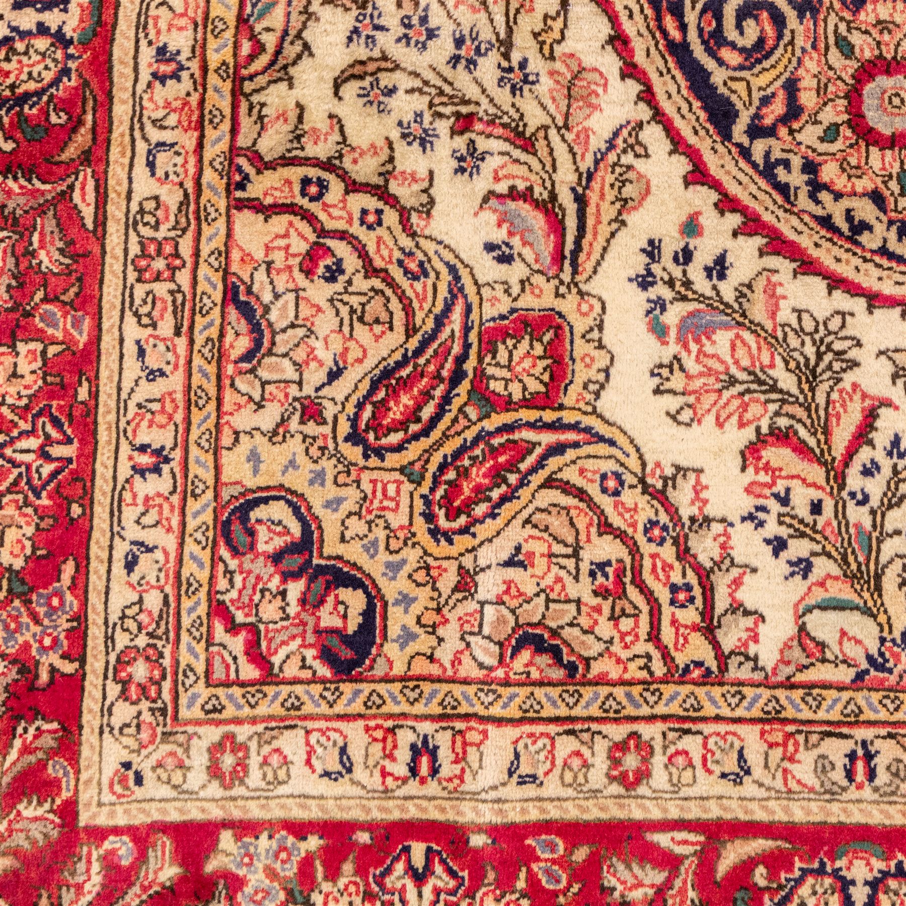 West Central Persian Sarouk hand-knotted carpet, ivory field with central ornate medallion and scrolling vines and palmettes, surrounded by large stylized boteh motifs and flowering foliage, enclosed by a madder-red border of palmettes and floral vine ornament between multiple guard stripes, cotton fringe ends 