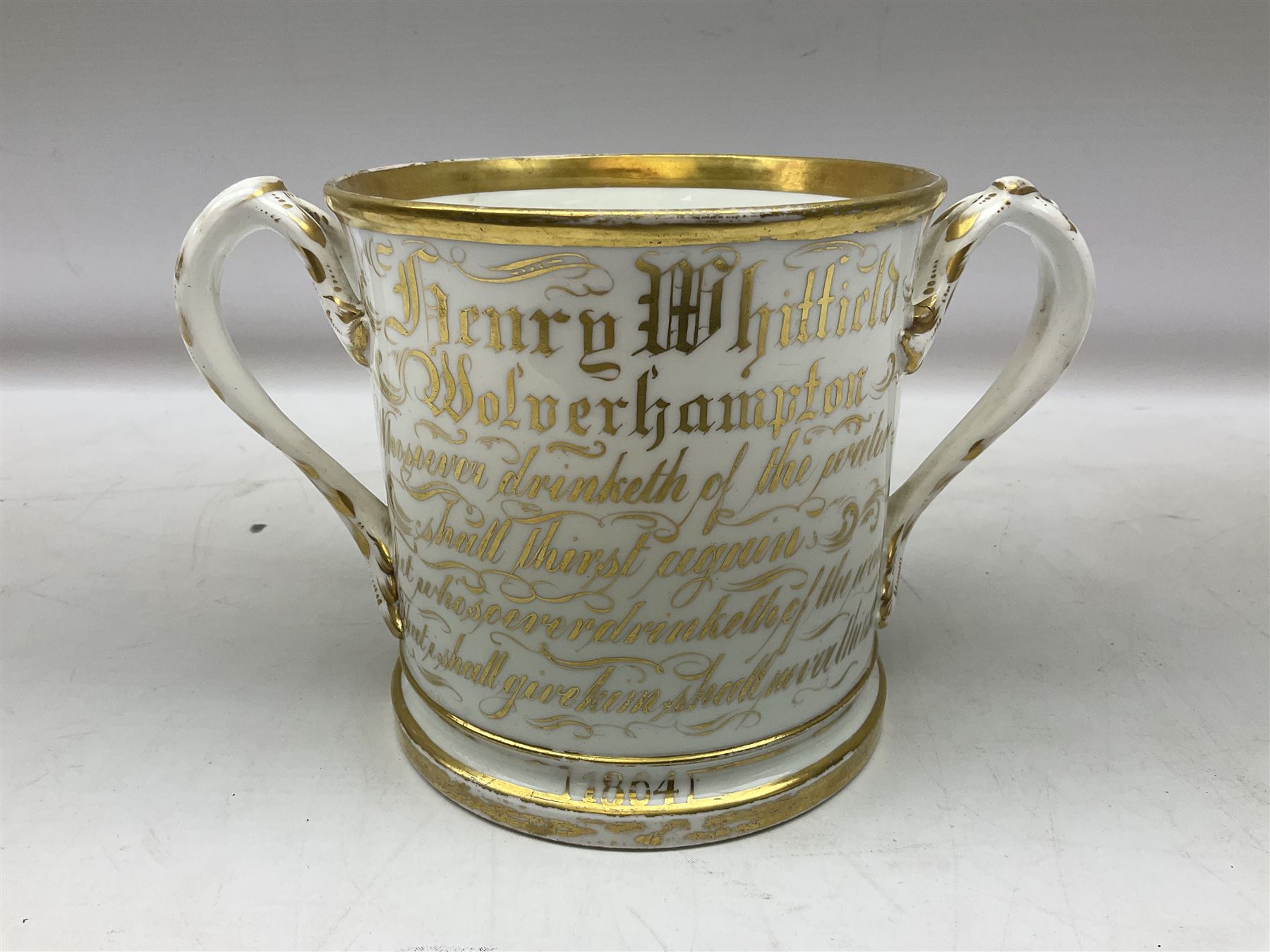 19th century loving cup, with decorated with religious iconography, a gilt rim and writing 'Henry Whittirld Wolverhampton, Whoever drinketh of the water shall thirst again but who soever drinketh of the water that i shall give him shall never thirst',  H14cm