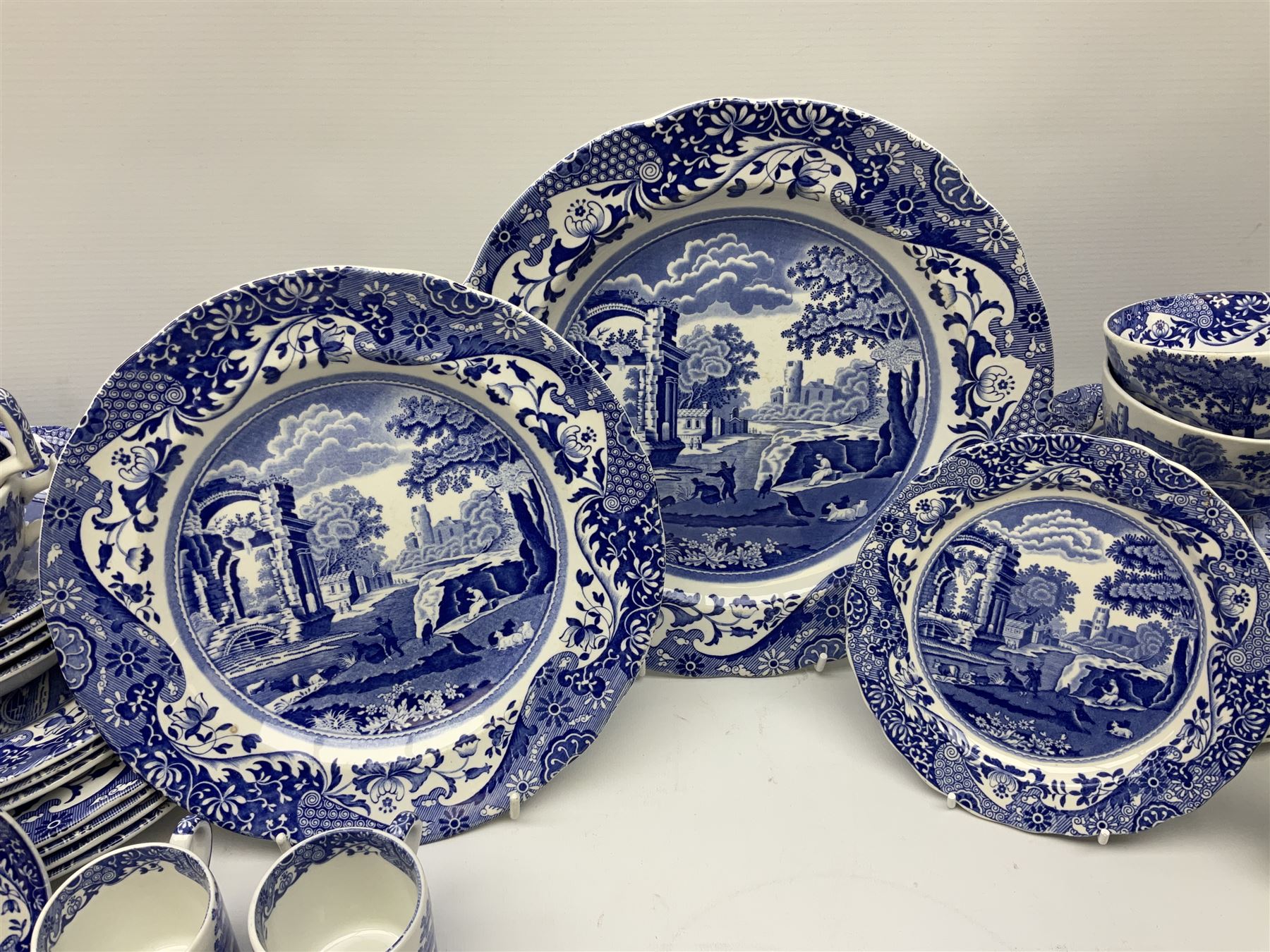 Spode blue and white Italian pattern dinner and tea wares, comprising five dinner plates, four side plates, seventeen side plates, four bowls, ten tea cups and twenty one saucers, five coffee cans and six saucers, and a flan dish, with blue and black printed marks beneath 