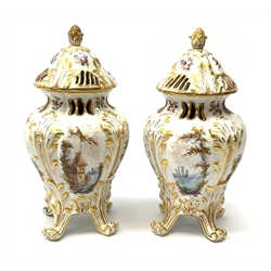 A pair of Continental porcelain vases and covers, each of baluster form raised upon four scroll feet, with pierced bud finial covers, the bodies painted with landscape and figural scenes and further detailed with flowers and heightened with gilt, with gold Hochst style mark beneath,  H22.5cm. 