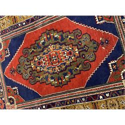 Turkish Taspinar rug, blue ground with central lozenge and medallion, the outer borders decorated with stylised motifs