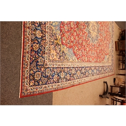  Meshed multicoloured carpet, red field with central floral medallion centre and spandrels with repeating palmette striped border, 437cm x 320cm  
