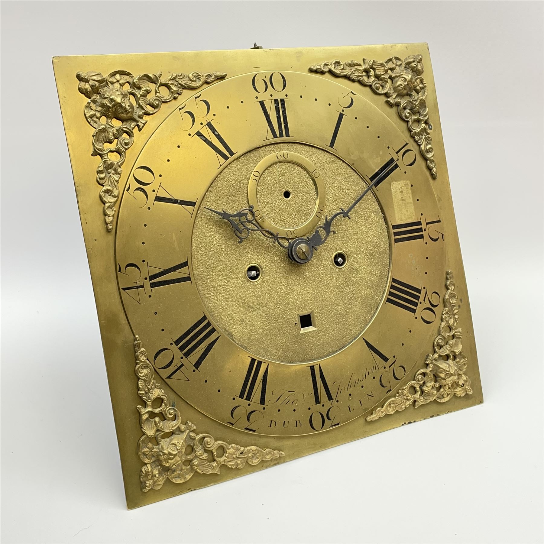 Late 18th century clock movement and dial, square brass dial with Arabic and Roman chapter ring signed 'Thos. (Thomas) Johnston, Dublin', with subsidiary seconds dial and calendar aperture, the dial set with ornate mask cast spandrels, twin train eight day movement striking on bell, with anchor escapement (34.5cm x 34.5cm, 13 1/2