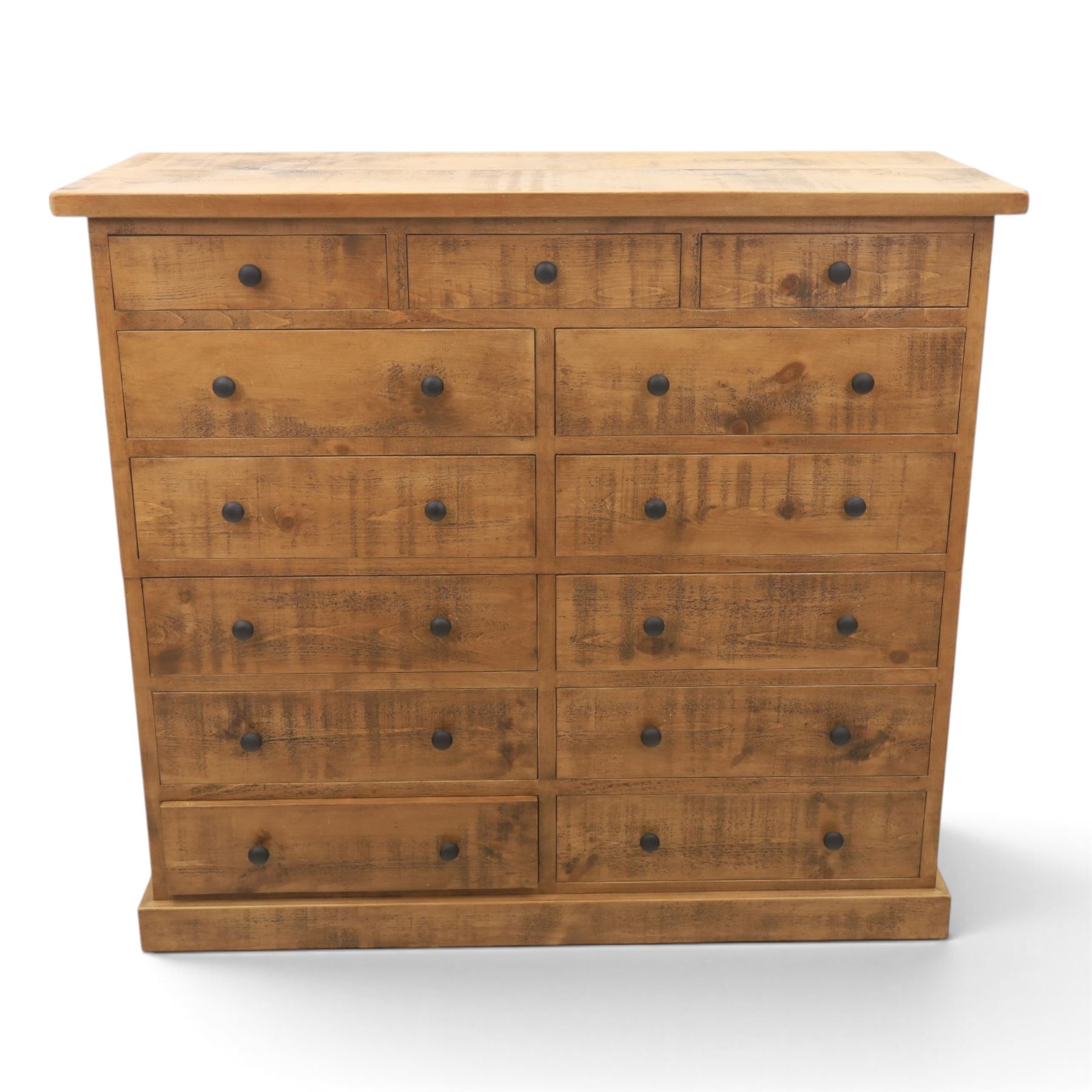 Indigo Furniture - large rustic oak combination chest, three drawers above ten drawers, with blackened pulls, raised on a plinth base