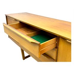 Mid-20th century teak sideboard, fitted with a fall-front cupboard, three drawers including a green baize-lined cutlery drawer, and a double cupboard, with integrated handles, on sleigh supports
