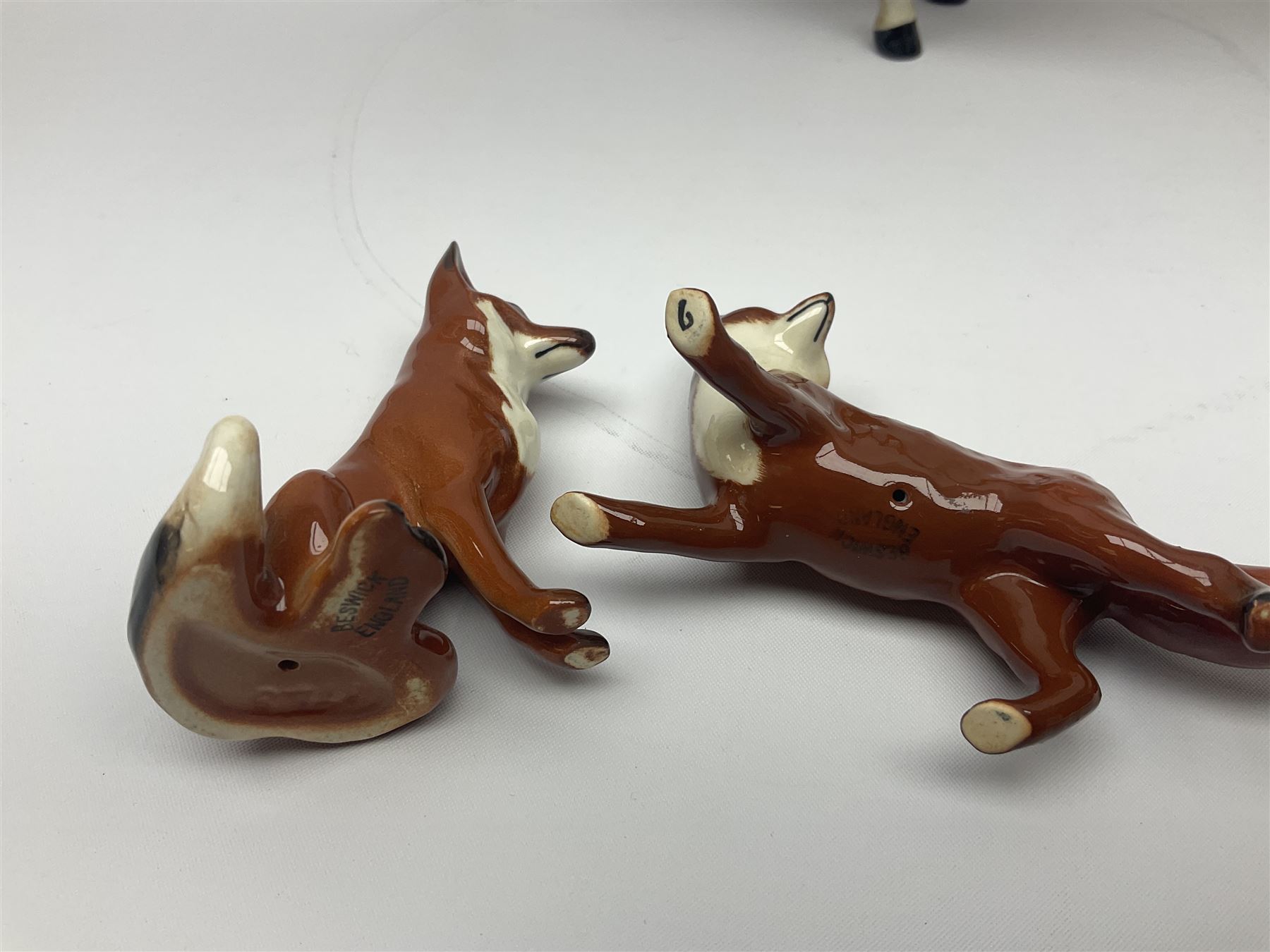 Beswick hunting group, comprising huntswoman on dappled grey horse no 1730, huntsman on bay horse no 1501, two fox figures no 1440 and 1748, and four fox hounds, all with printed marks beneath (8)