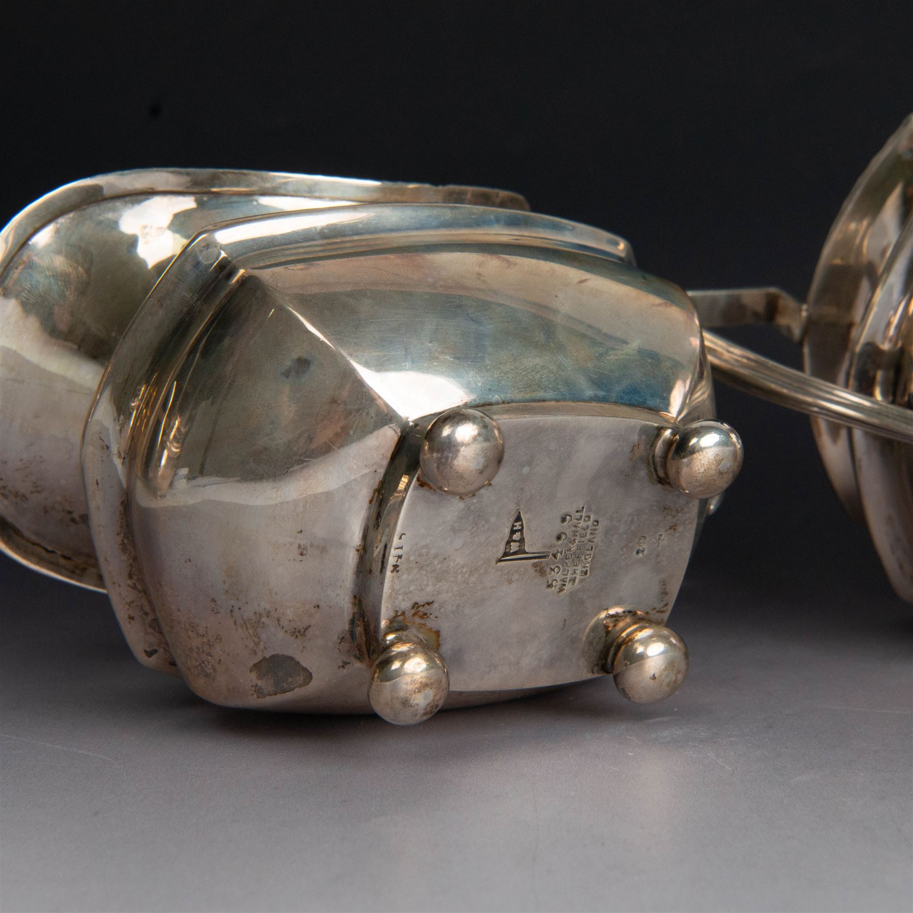 Early 20th century three piece silver tea service, comprising teapot, open sucrier and milk jug, all with oblique gadrooned rim, engraved initial to body and upon four bun feet, the teapot with Bakelite type handle and finial, hallmarked Walker & Hall, Sheffield 1912, contained within an oak presentation case with silk lining