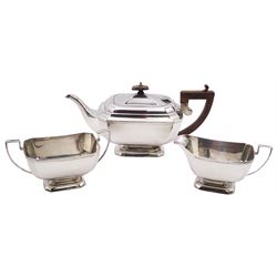 1930's three piece silver tea service, comprising teapot, twin handled sucrier, and milk jug, each of rectangular form with canted corners, the teapot with wooden scroll top handle and finial, hallmarked Henry Clifford Davis, Birmingham 1931, approximate gross weight 35.91 ozt (1117 grams)